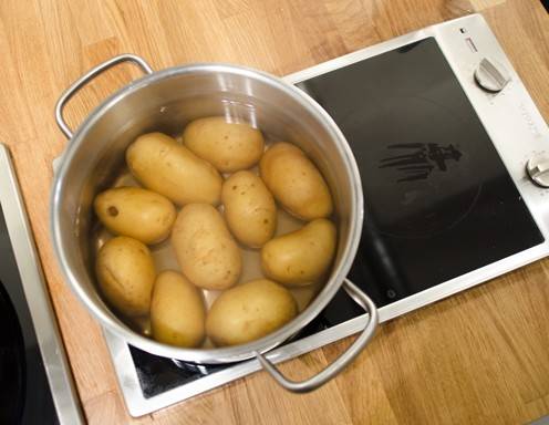 <p>Die Erd&auml;pfeln in hei&szlig;em Wasser kochen.</p>